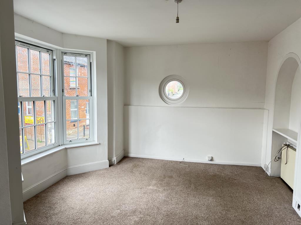 Lot: 145 - THREE-BEDROOM MAISONETTE FOR INVESTMENT OR OCCUPATION - Living room with white walls beige carpet and bay window